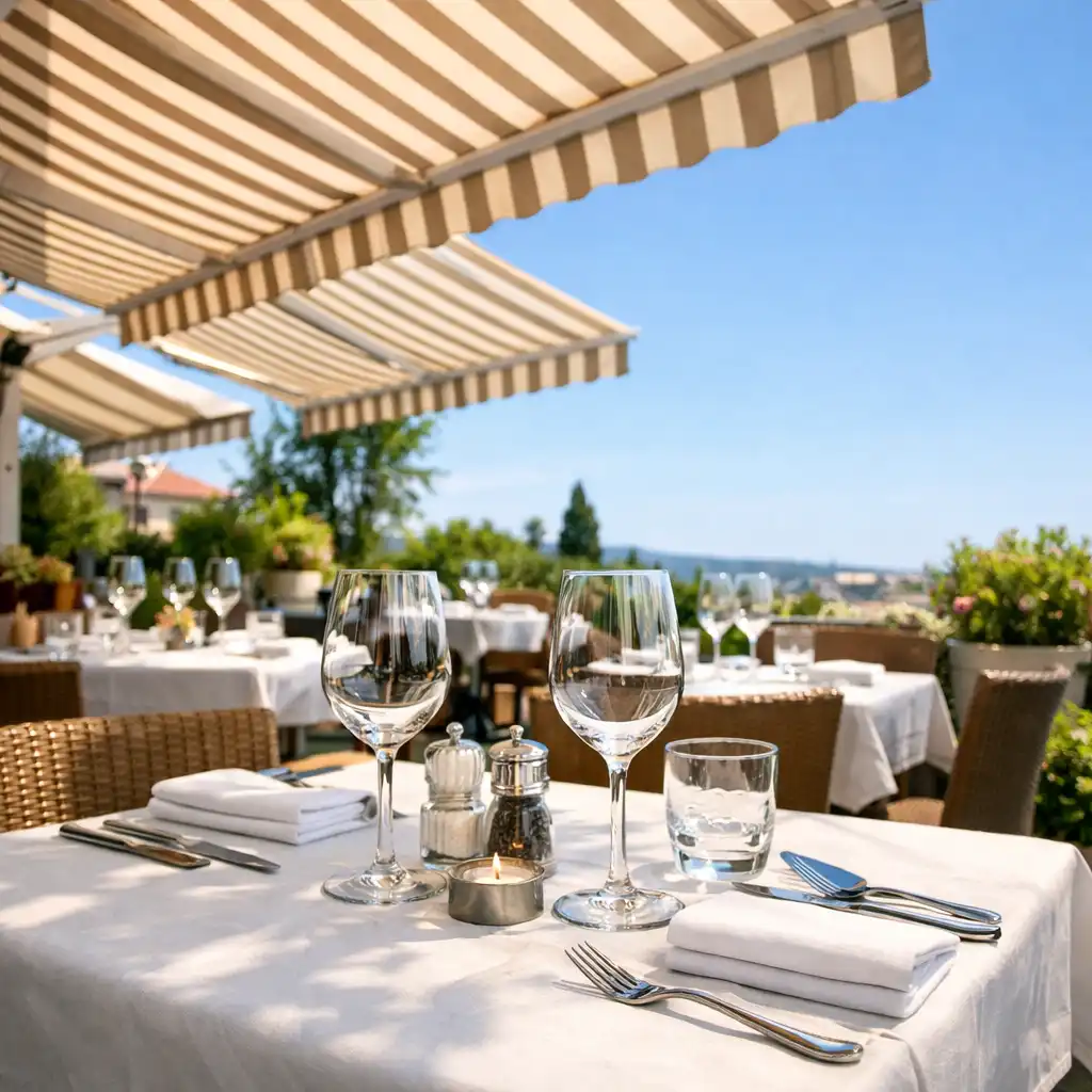 Terrasse en journée avec stores rayés et tables dressées